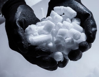 worker-holding-dry-ice-pellets-with-thick-black-gloves